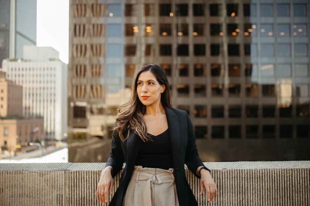 Image of author in downtown Los Angeles wearing a black top and blazer and tan slacks.